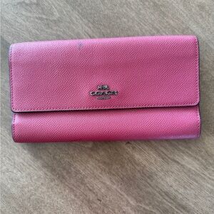 Coach magenta wallet
7 3/4 x 4 1/2 x 3/4
2 ink marks on front. 
Snap closure